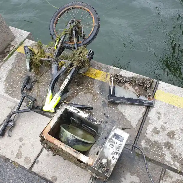 Aus der Donau geborgenes Fahrrad und Mikrowelle am Kai bei der Reichsbrücke